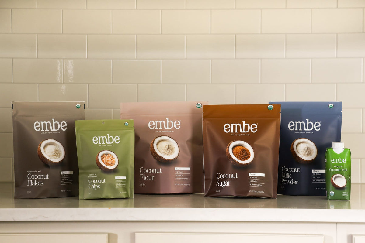 embe's product lineup of coconut products on a marble kitchen counter infront of a tiled wall